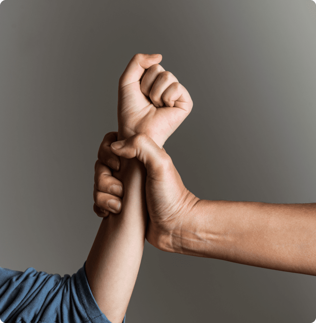 Two hands demonstrating a self-defense wrist grab escape technique against a plain background.
