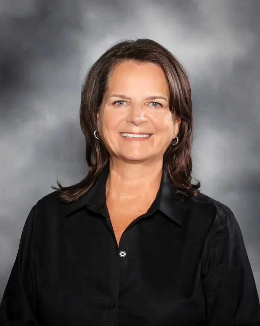 A woman in black shirt smiling for the camera.